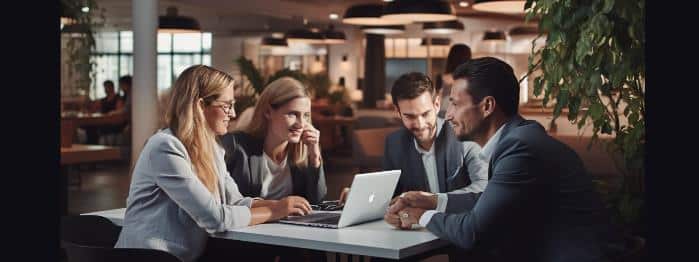 Four employees sitting at a desk discussing a guided selling tool