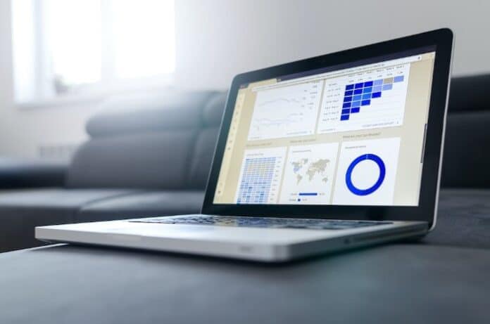 An open laptop displaying various charts, including a logarithmic chart in the top left corner